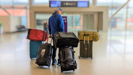 Selection of travel bags for long-haul flights from Australia including anti-theft backpack, carry-on and personal item bag laid out at an airport.