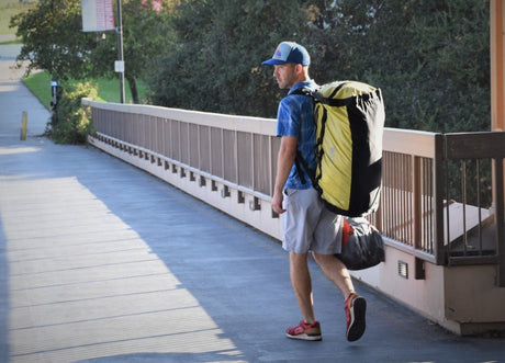 Large travel duffel bag packed with gym gear including shoes, towel and water bottle, suitable for active Australian travellers.