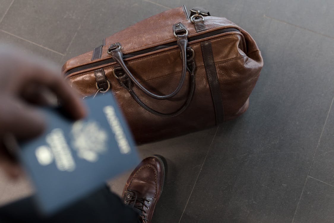 Travel tech accessories laid out including portable power bank, universal adaptor, noise-cancelling earbuds and compact laptop stand for digital nomads.