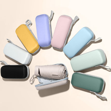 Compact travel umbrellas in colourful zip cases, with one case open to show the folded umbrella