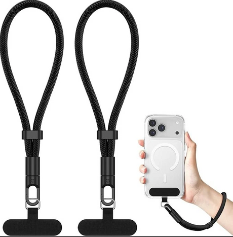 Two black braided lanyard-style phone straps with metal clips and black rubber tips, shown on a white background. A hand on the right holds a clear phone case with a black wrist strap attached, demonstrating use.