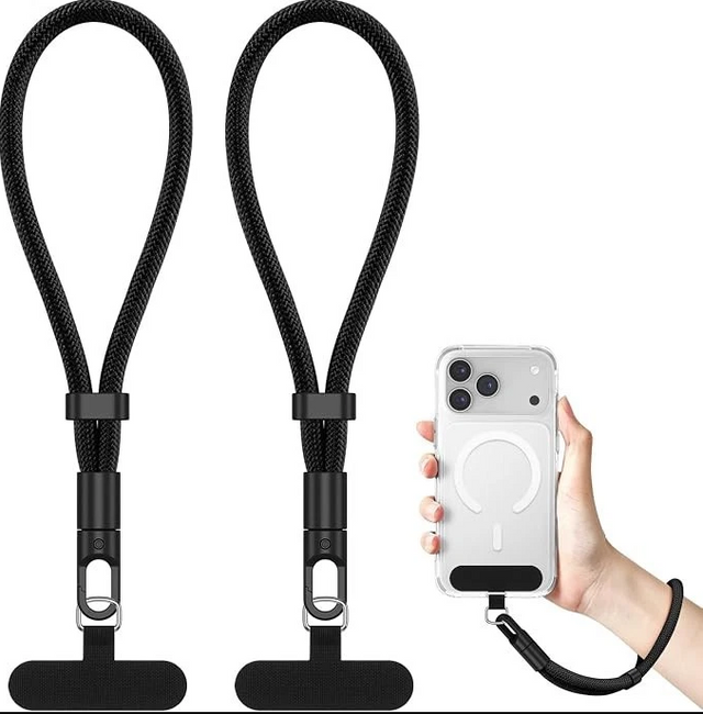 Two black braided lanyard-style phone straps with metal clips and black rubber tips, shown on a white background. A hand on the right holds a clear phone case with a black wrist strap attached, demonstrating use.