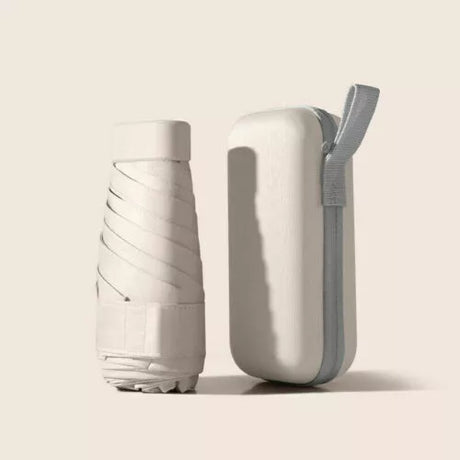 Beige folded compact travel umbrella beside its matching zip-up carry case