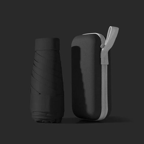 Black folded compact travel umbrella beside its matching zip-up carry case