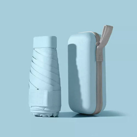 Light blue folded compact travel umbrella beside its matching zip-up carry case