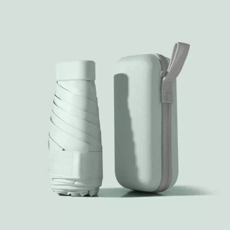 Pale green folded travel umbrella beside its matching zip-up carry case