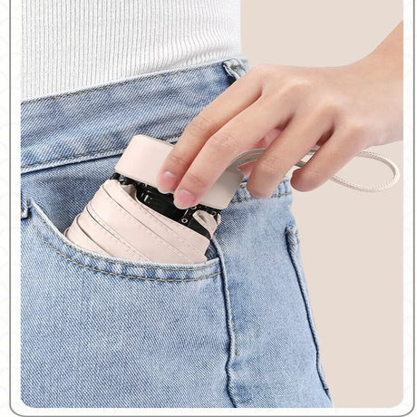 Folded compact travel umbrella slipping into a jeans pocket